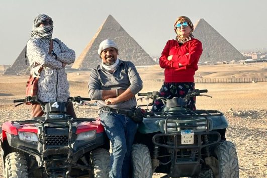Three friends running a tour around the Pyramid in the Egyptian desert, taking photos during a private adventure tour with King David Tours